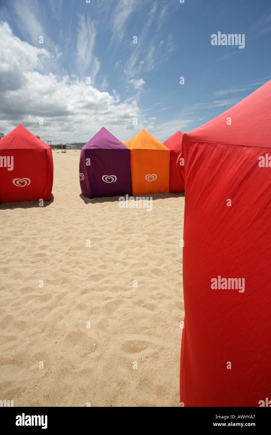 Seasonal cabanas on the wide beaches at the coastal resort town of Nazaré on Portugal s Atlantic seaboard Stock Photo