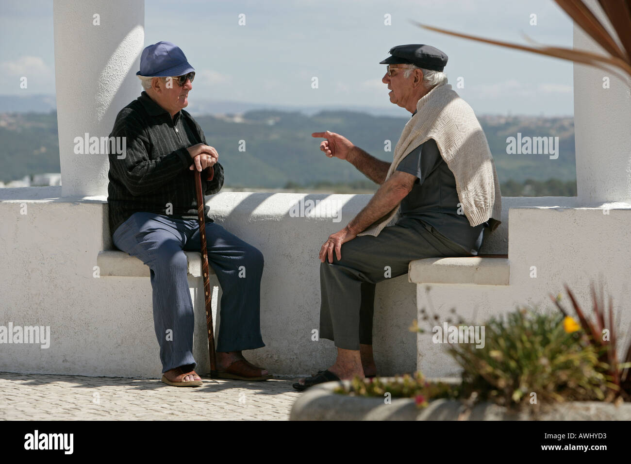 Two senior residents of Nazaré Portugal have a conversation on the Promontório do Sitio clifftop area above town Stock Photo