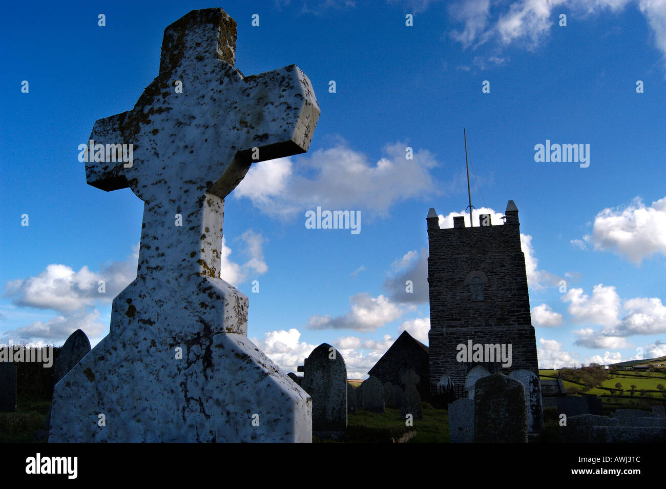 Silhouetted gravestone with Forrabury church in background Boscastle Stock Photo