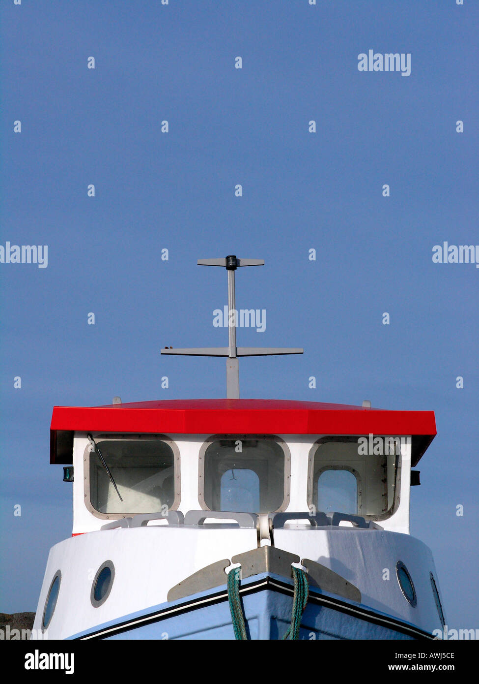 Pilot house on a small fishing cutter against a bright blue sky Stock Photo