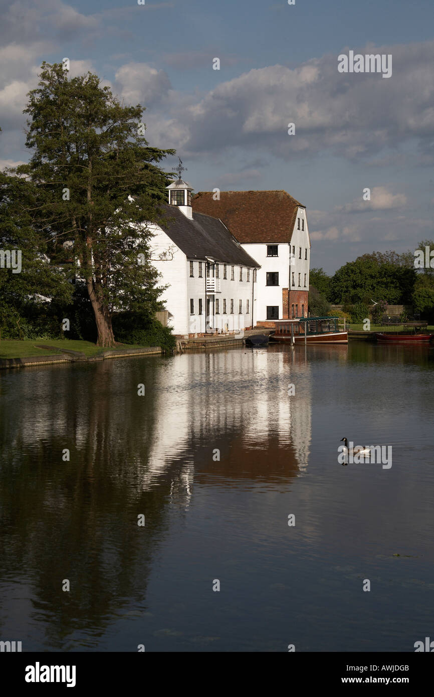 Hambleden Mill on weir with Canada goose and small barges near Henley on Thames on River Thames