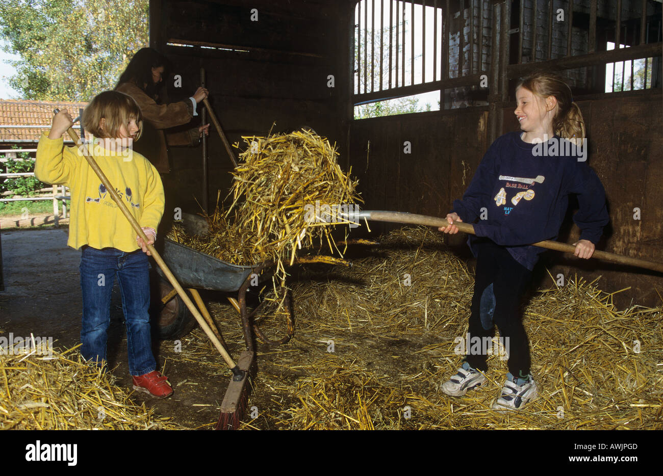 farm holidays two girls mucking out Stock Photo Alamy