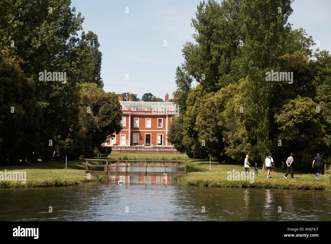 Fawley Court Museum through trees with small wooden footbridge near