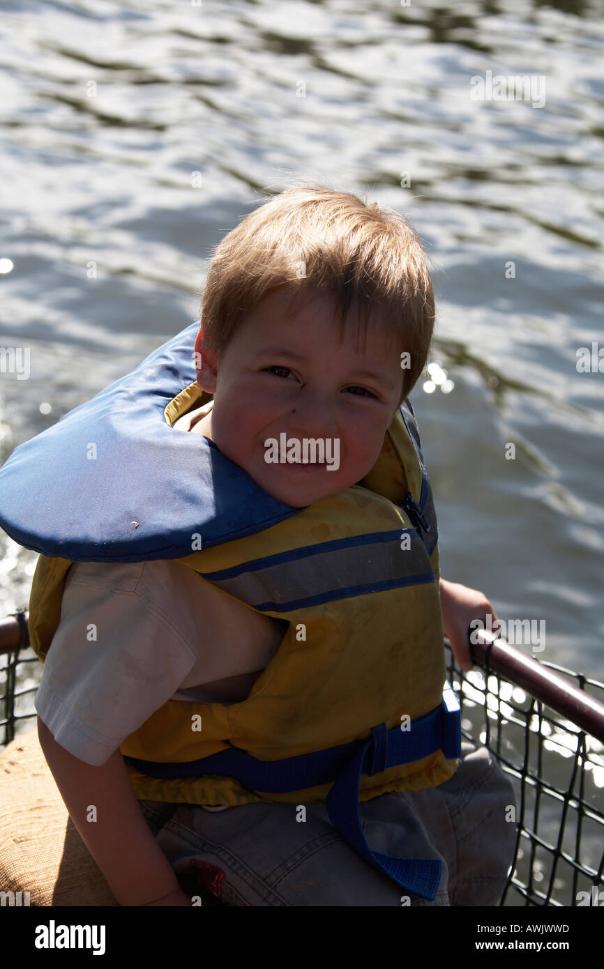Boy child wearing life jacket beside river near Marlow on River Thames