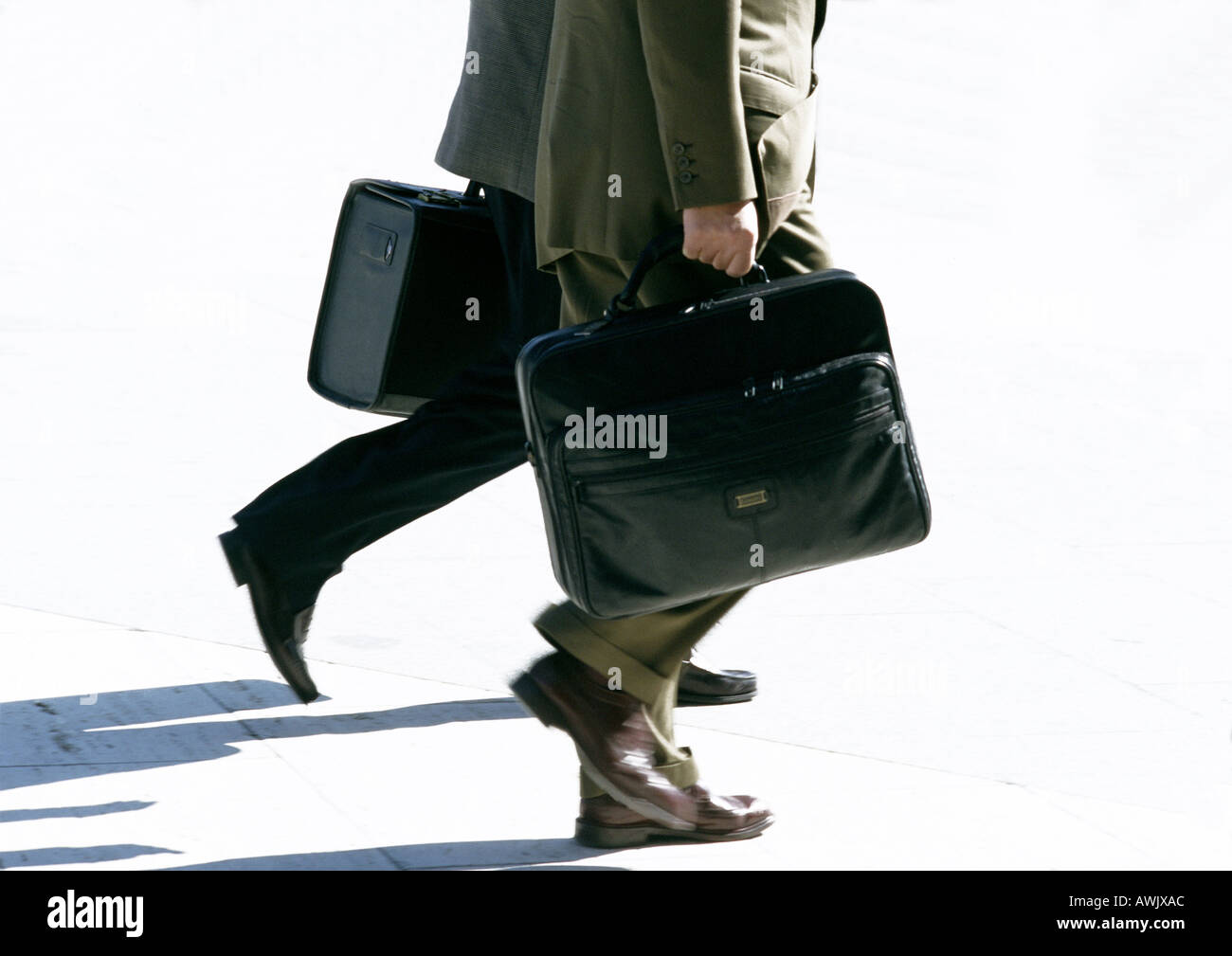 Businessmen walking with briefcases, view from waist down. Stock Photo