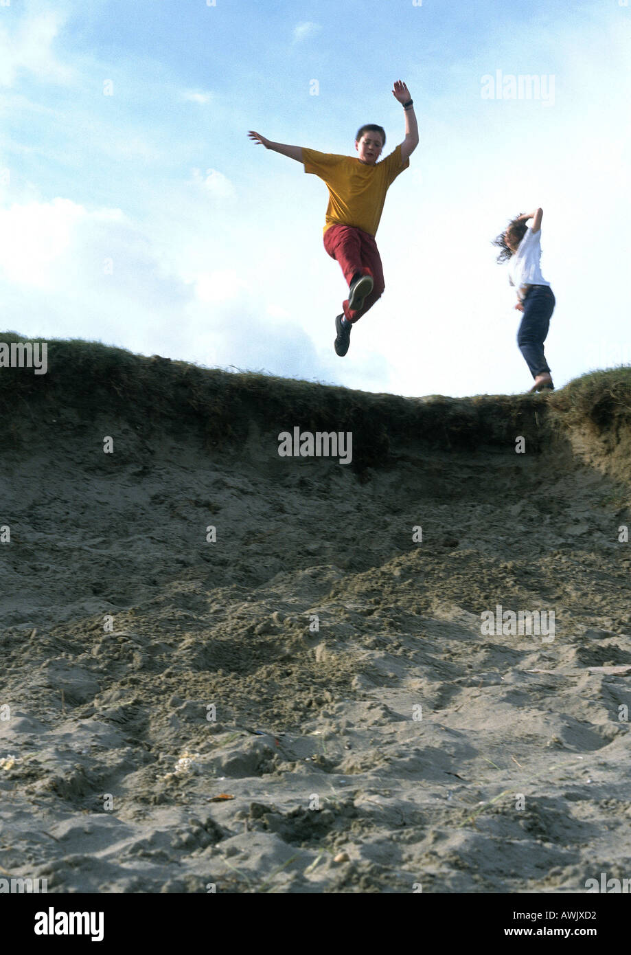 Young people jumping in sand Stock Photo Alamy