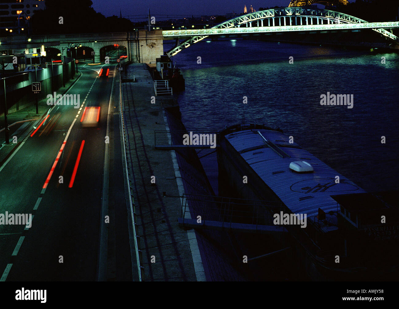 France, Paris, cars traveling on quai at night, blurry. Stock Photo