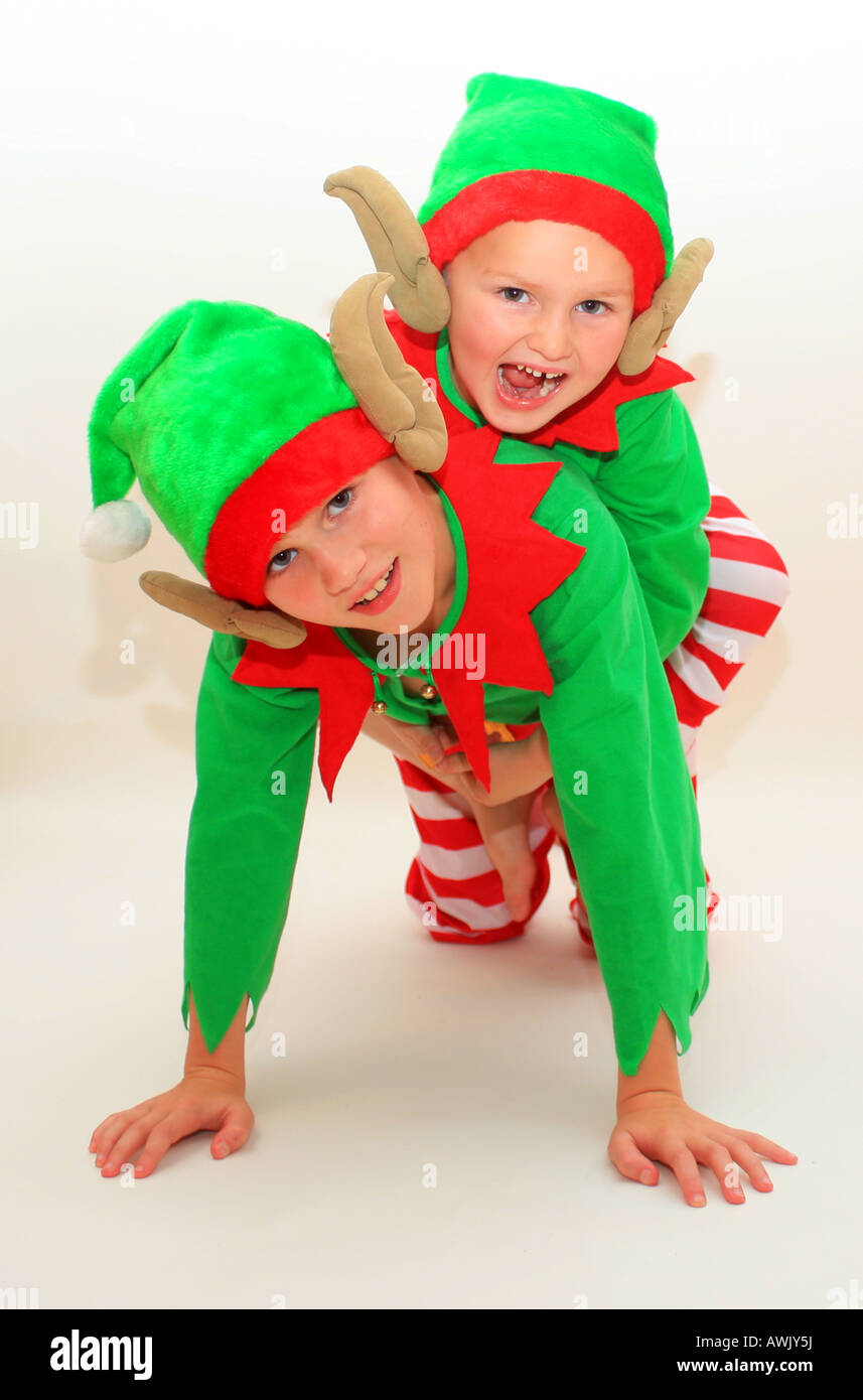 two boys in studio in pixie outfits one giving the other a piggie back Stock Photo