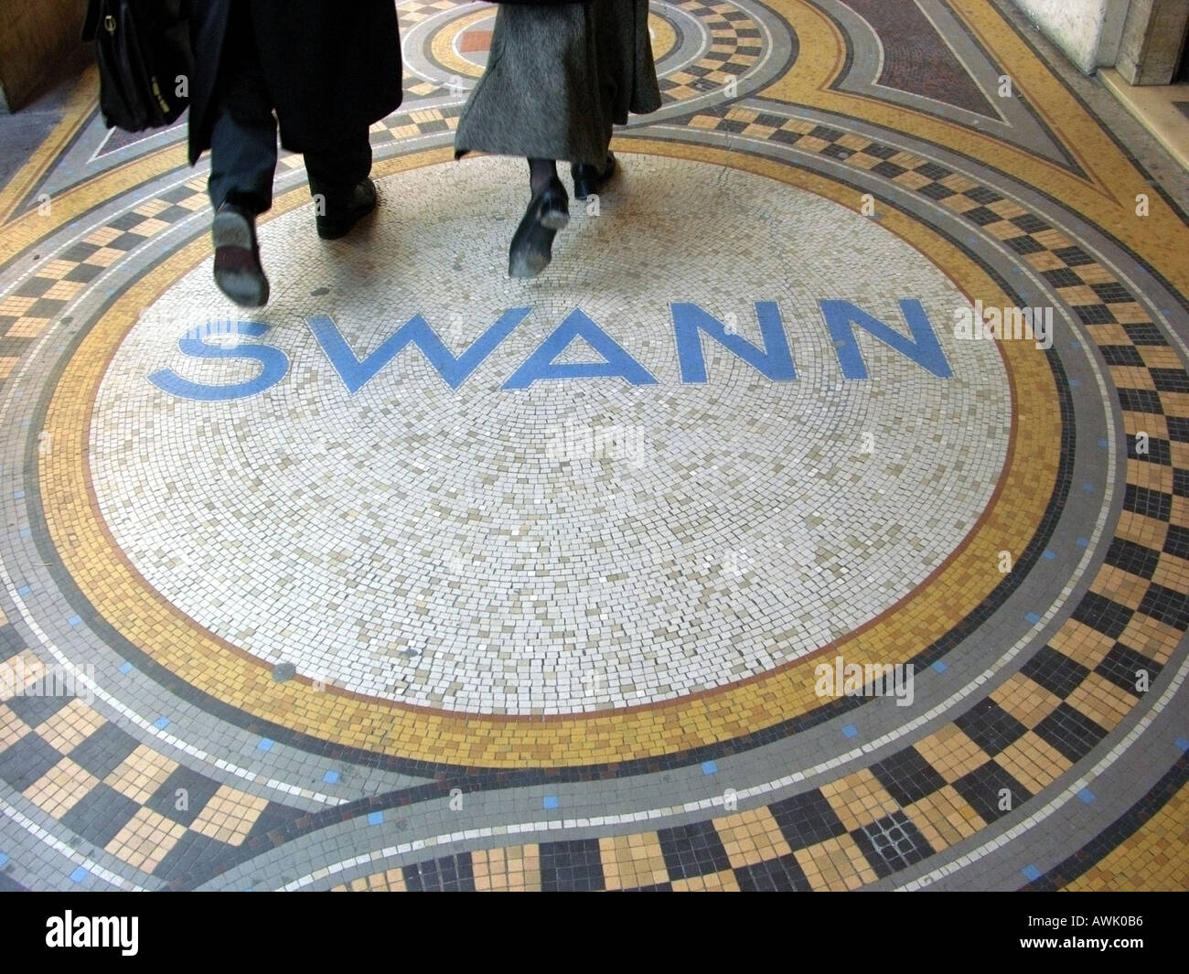 france ile de france paris rue de castiglione art nouveau mosaic pavement with the name swann and couple passing over it Stock Photo