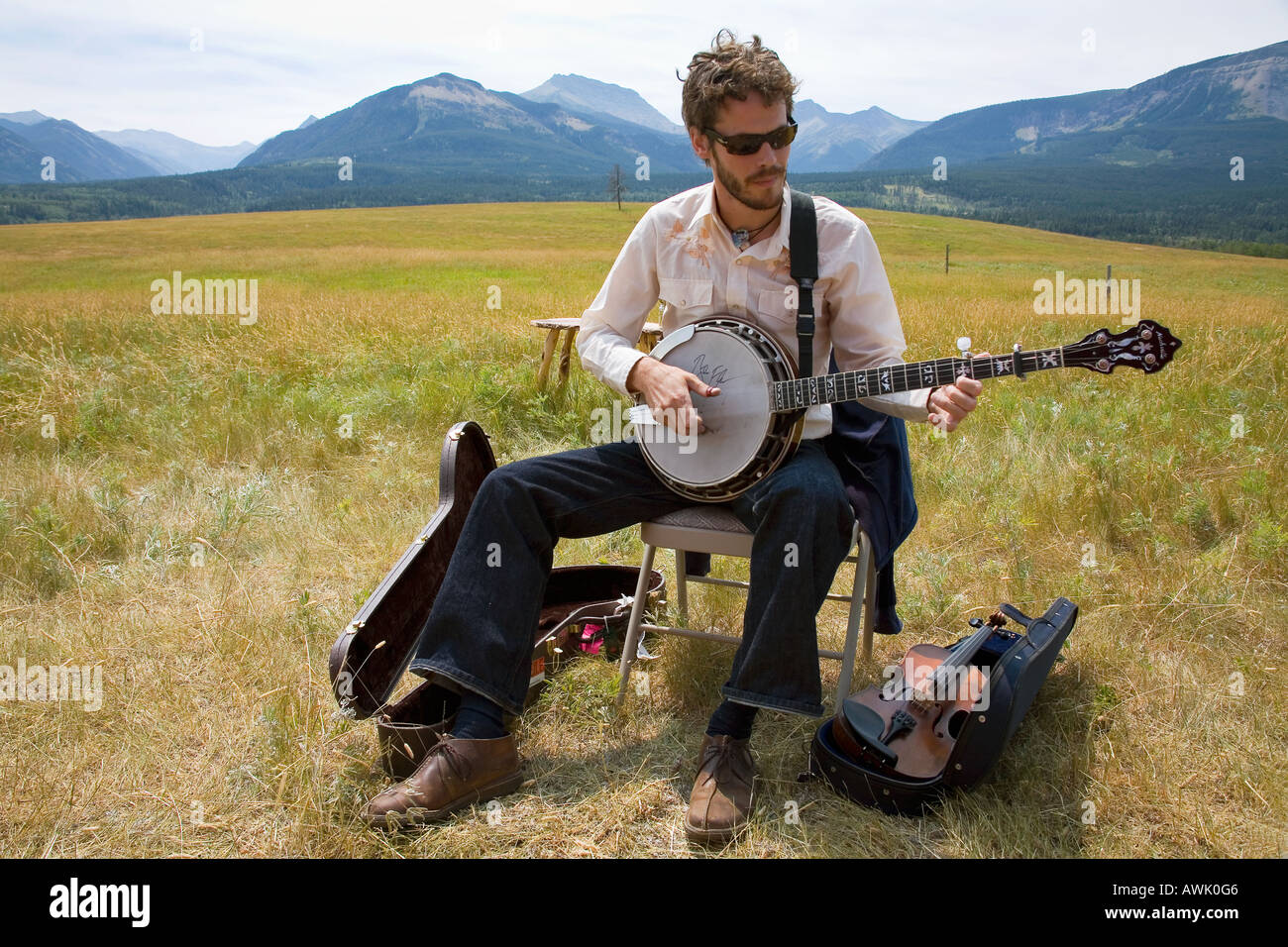 Musician playing for romantic wedding in open air in golden fields high in Rocky Mountains Alberta Canada Stock Photo