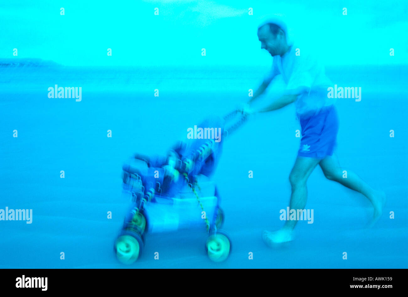 Side profile of man pushing pram on beach Stock Photo Alamy