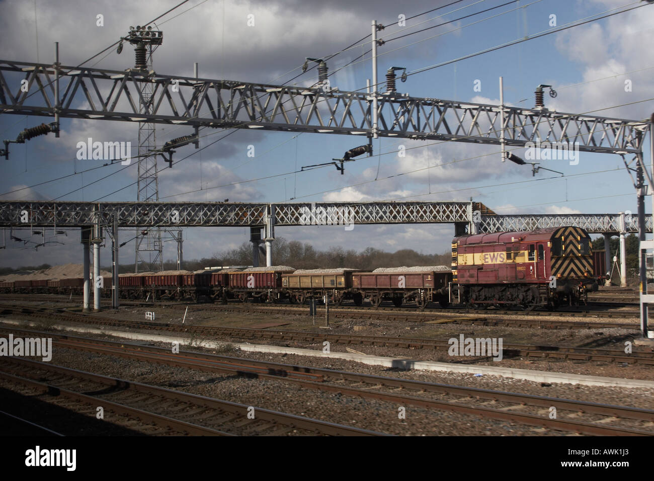 Electrified railway lines and goods train on tracks in midlands England