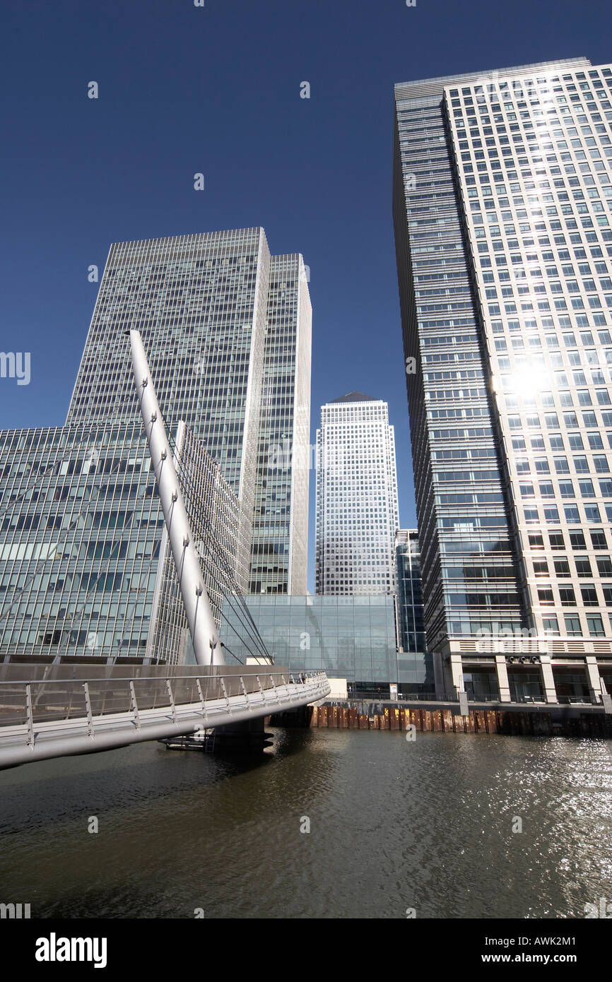 Canary Wharf tall modern office steel and glass skyscraper buildings with footbridge over West India Docks in Docklands Stock Photo