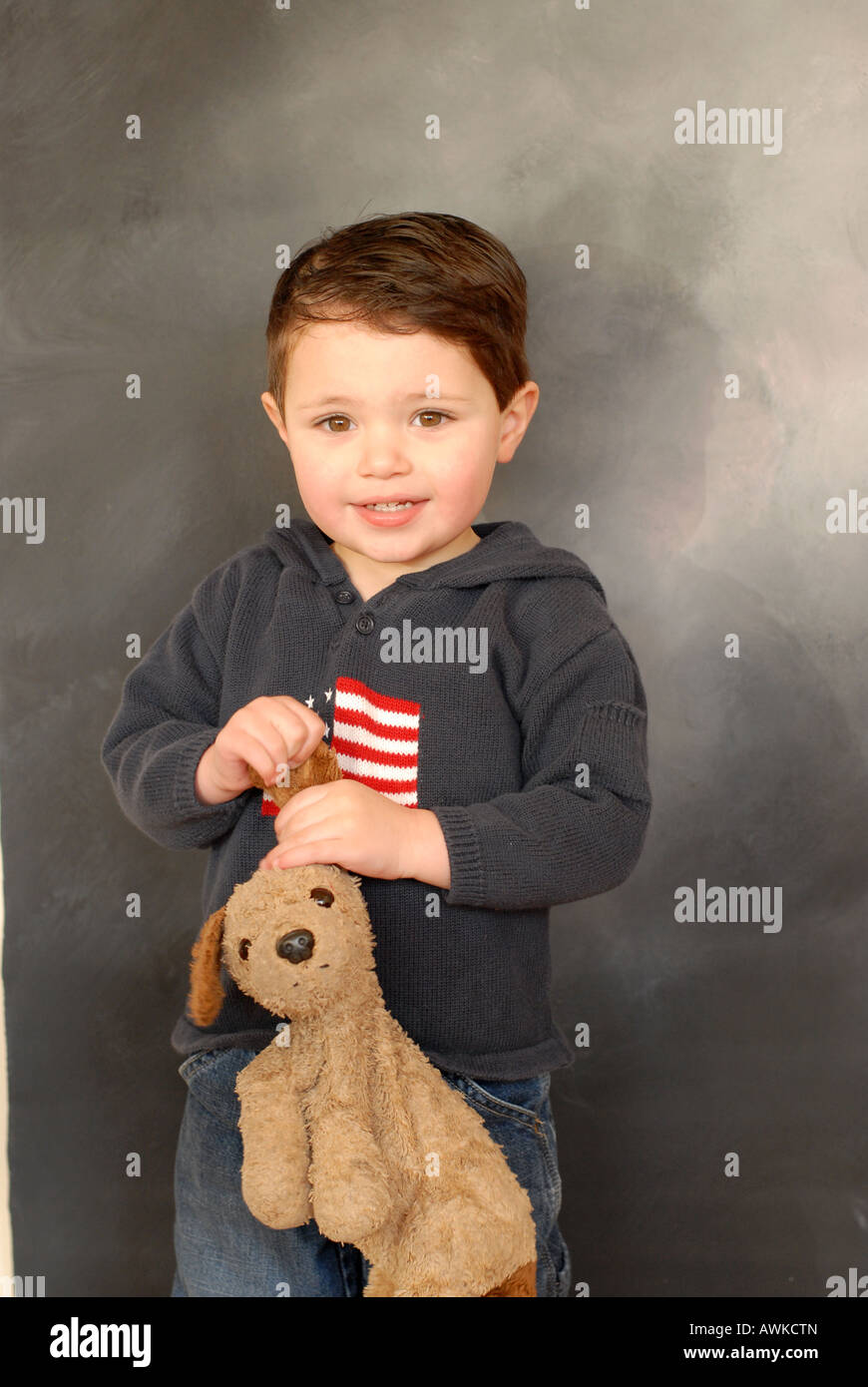 Two year old Hispanic American boy poses with his favorite toy, a pet