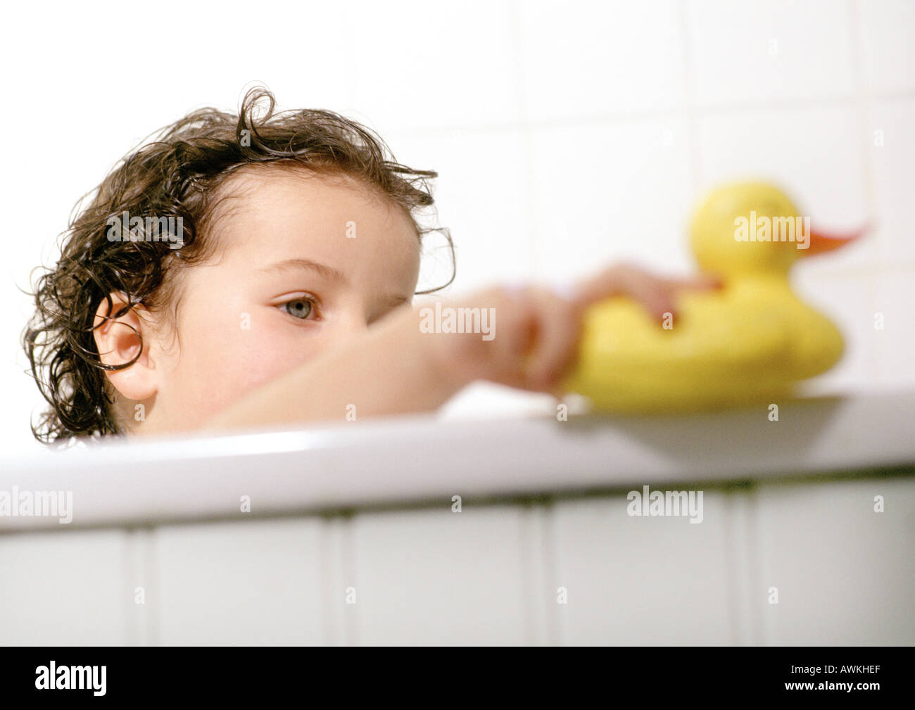 Young child playing with rubber duck in bath tub Stock Photo - Alamy