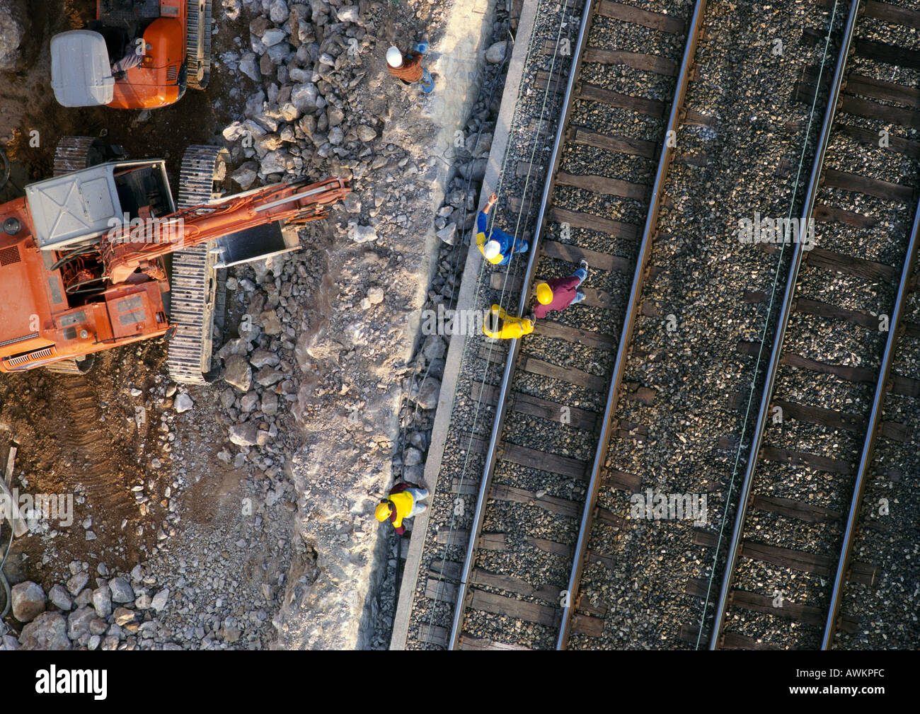 Men wearing hard hats, standing on rails, elevated view Stock Photo