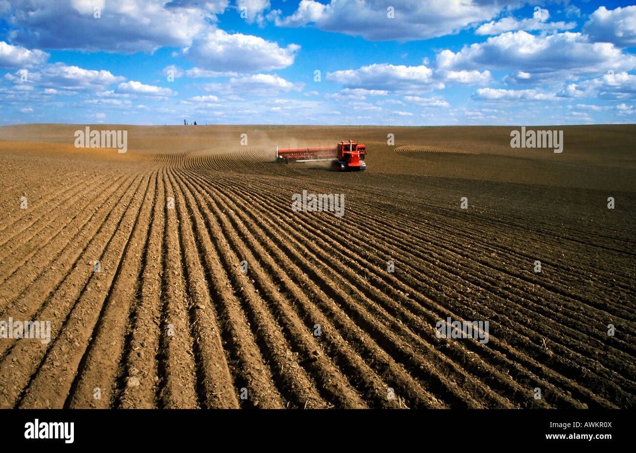 Farm equipment tilling rows in dirt field Agribusiness Washington State Stock Photo