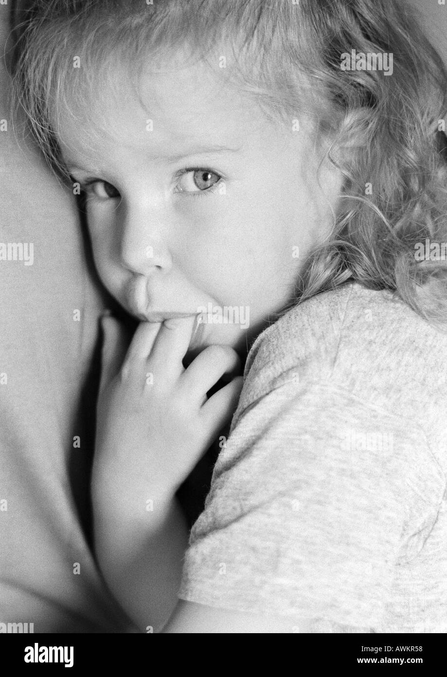 Girl with fingers in mouth, portrait, b&w Stock Photo
