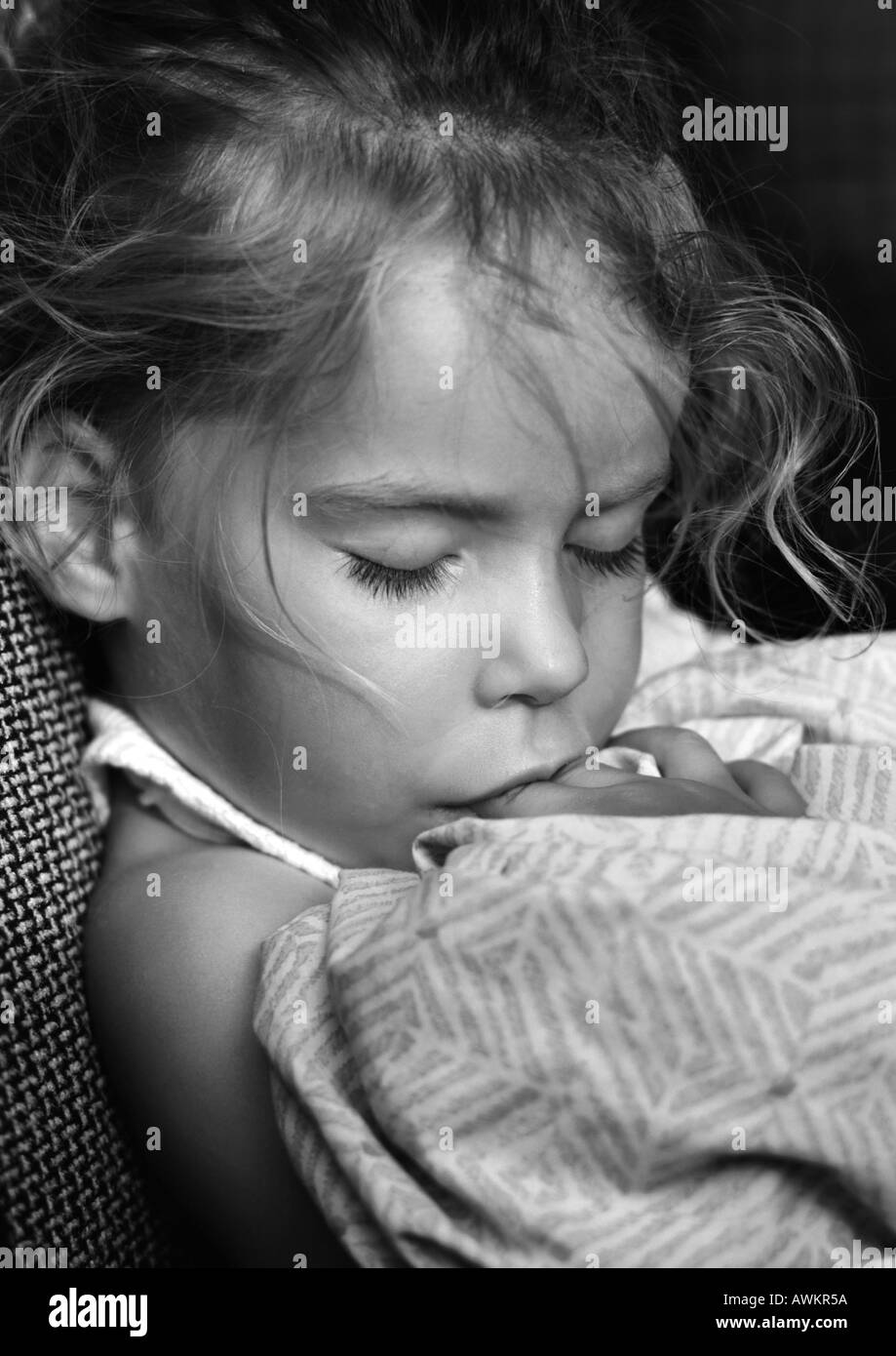 Girl sleeping with fingers in mouth, b&w Stock Photo