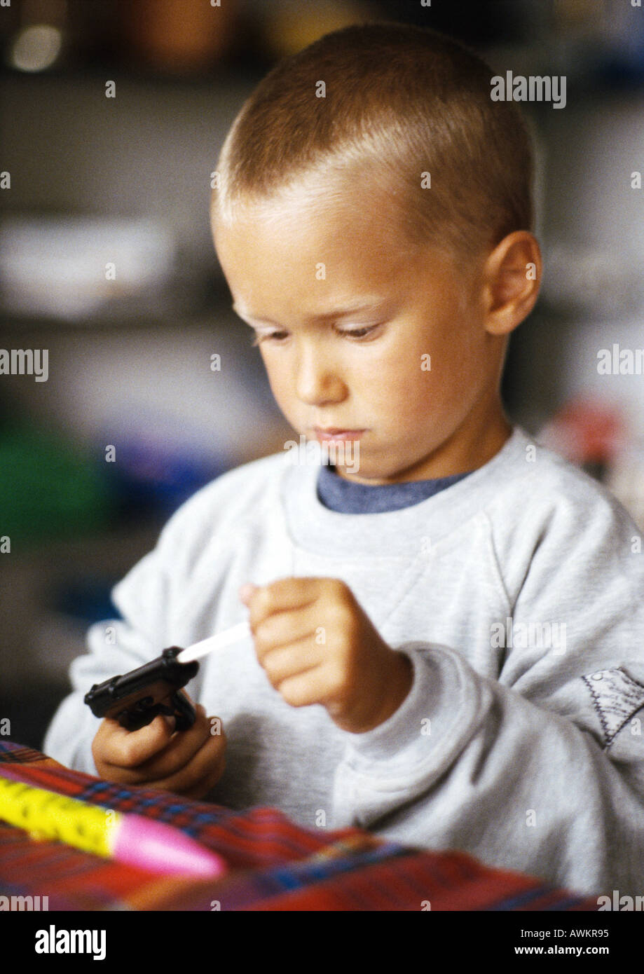 Little boy holding toy gun Stock Photo