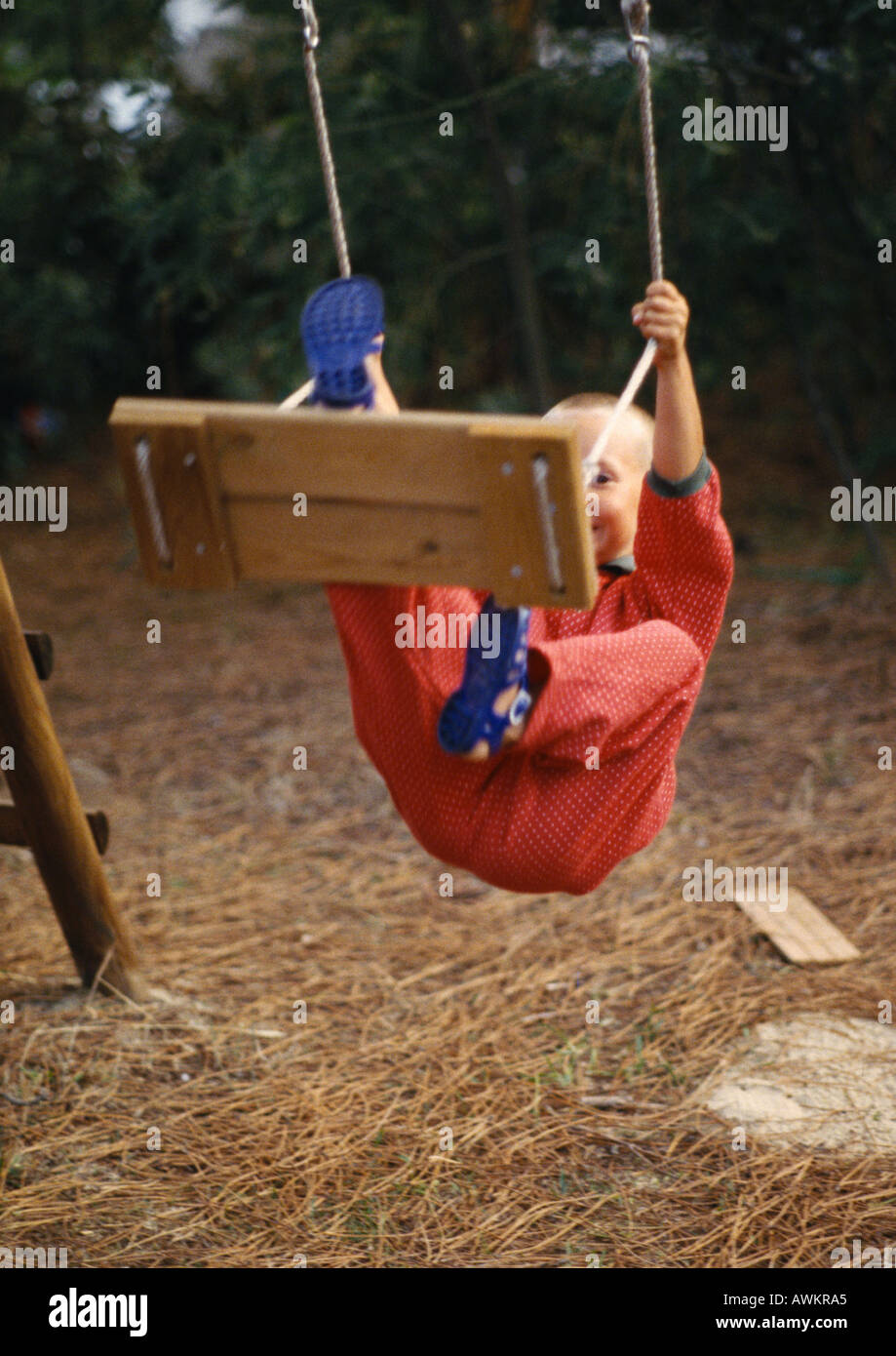 Boy hanging on swing Stock Photo