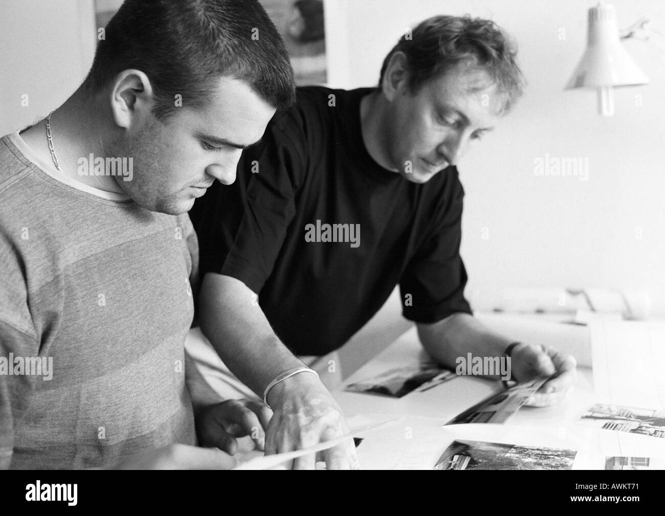 Two men looking at documents on desk, b&w Stock Photo