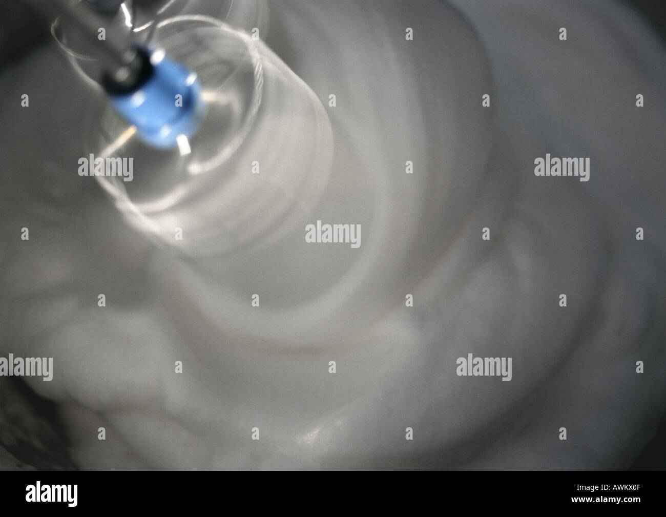 Electric mixer beating egg whites in bowl, closeup Stock Photo Alamy