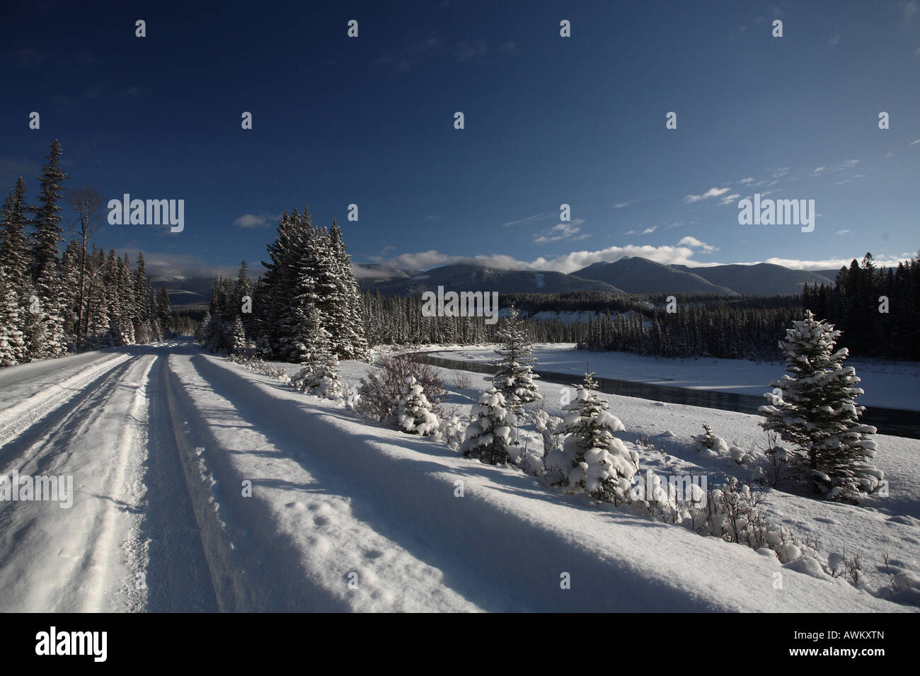 Snow covered road following a river Stock Photo - Alamy