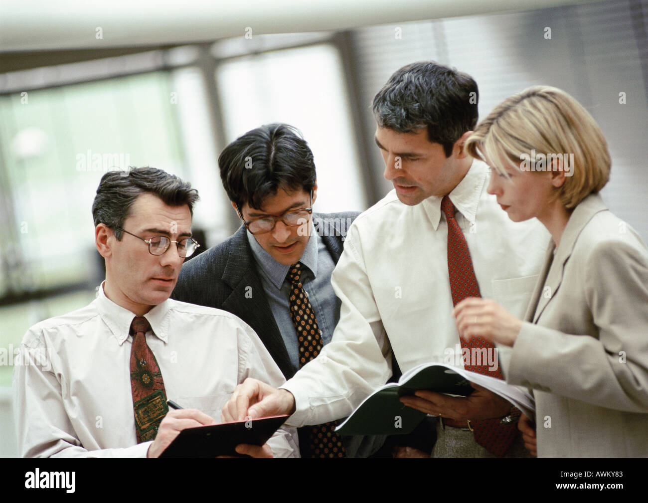 Four business people examining document Stock Photo