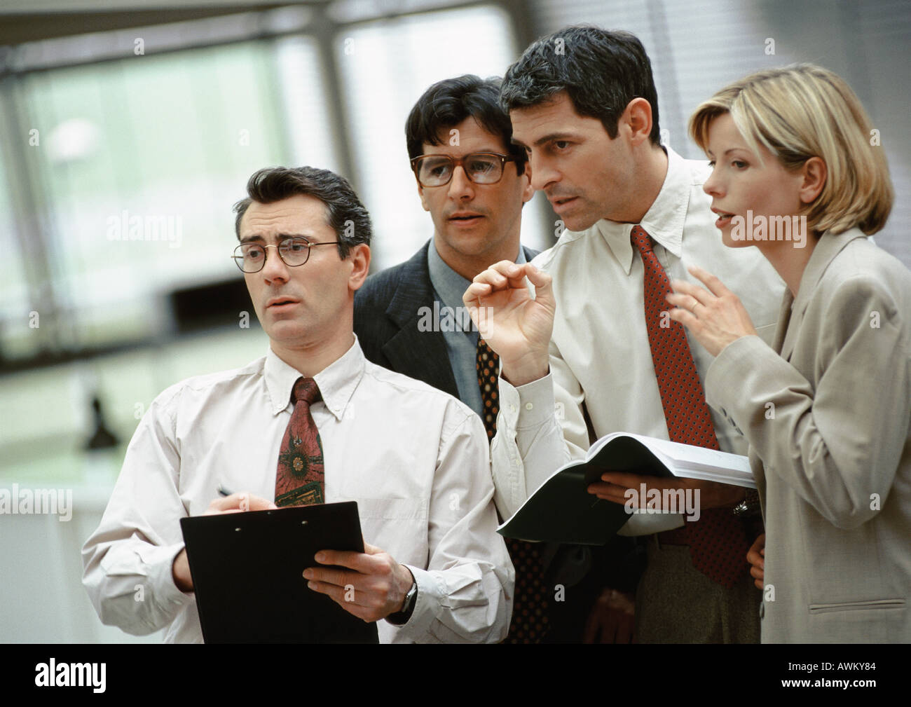 Four investors standing side by side, talking Stock Photo