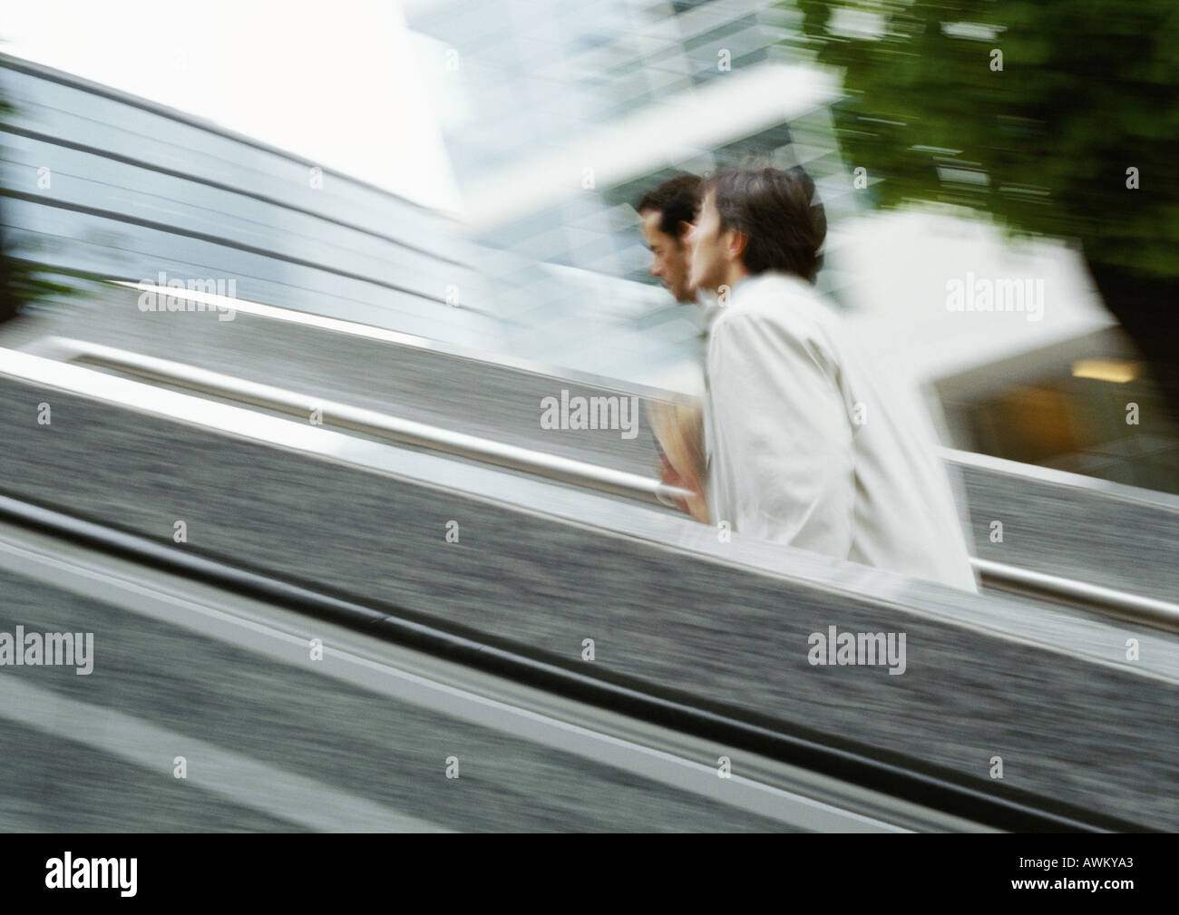 Two businessmen walking up stairs outside, blurred Stock Photo