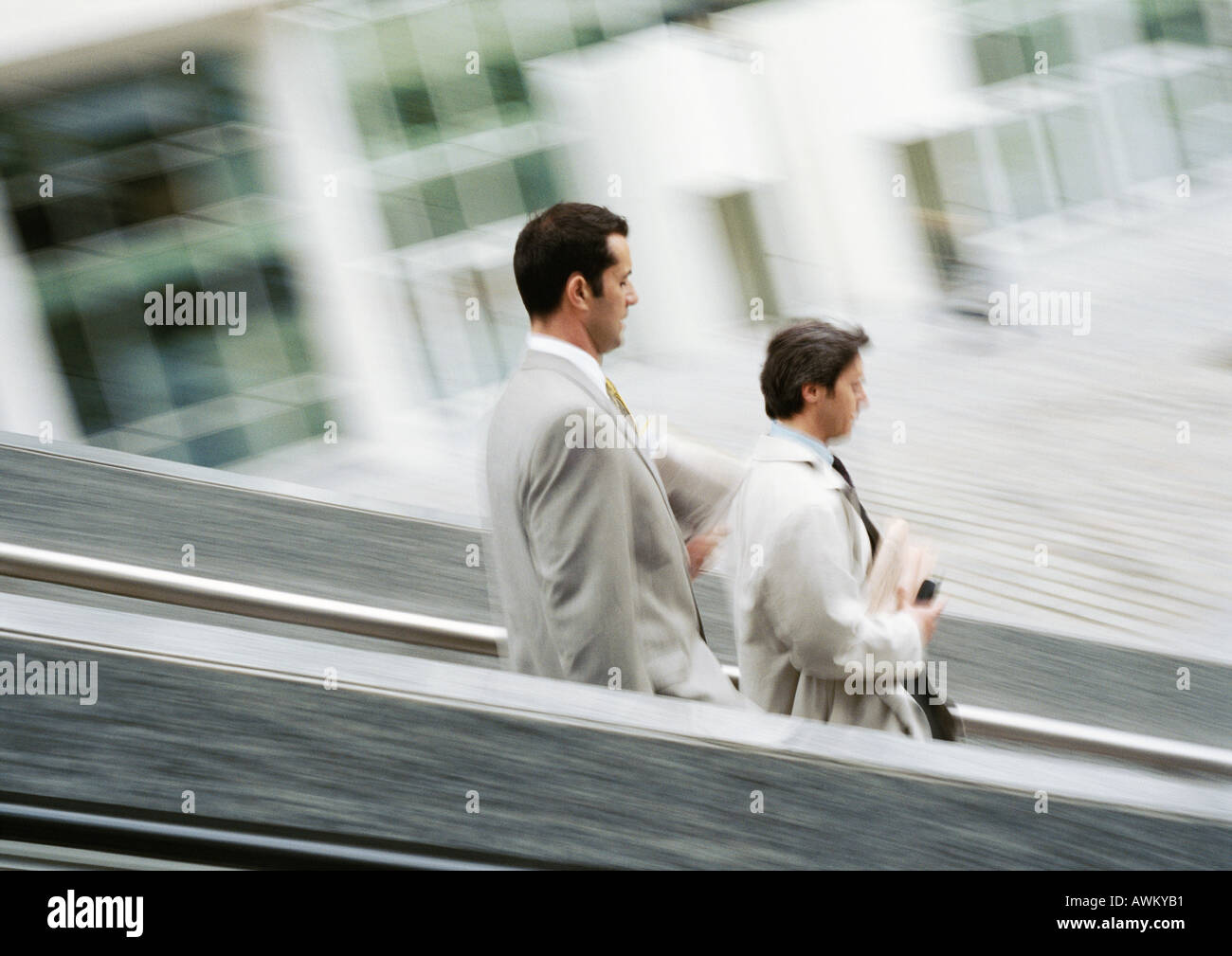 Two businessmen walking down stairs, blurred Stock Photo