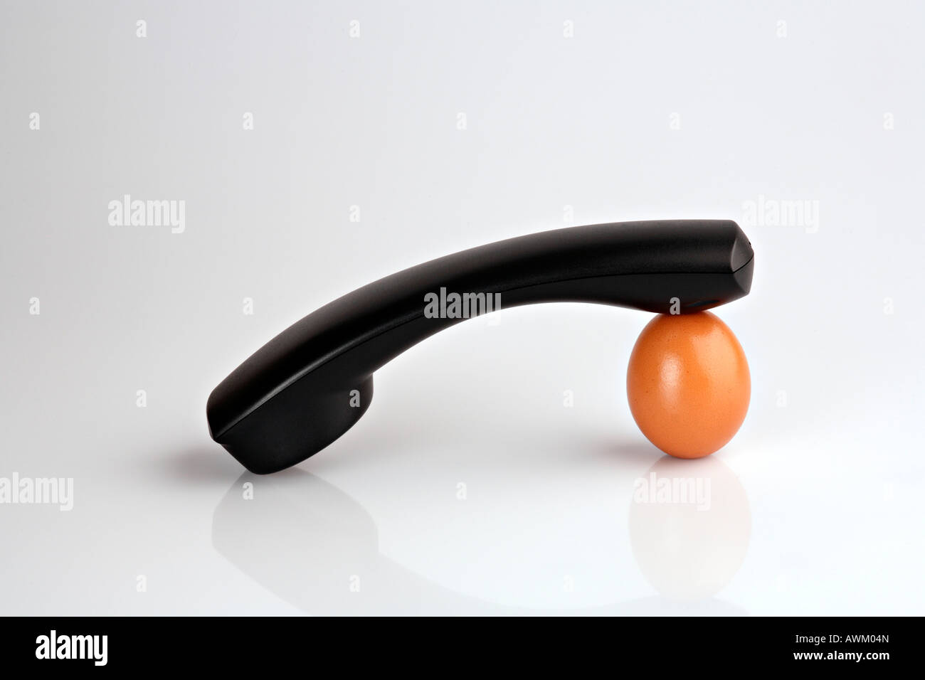Telephone receiver propped up on an egg Stock Photo
