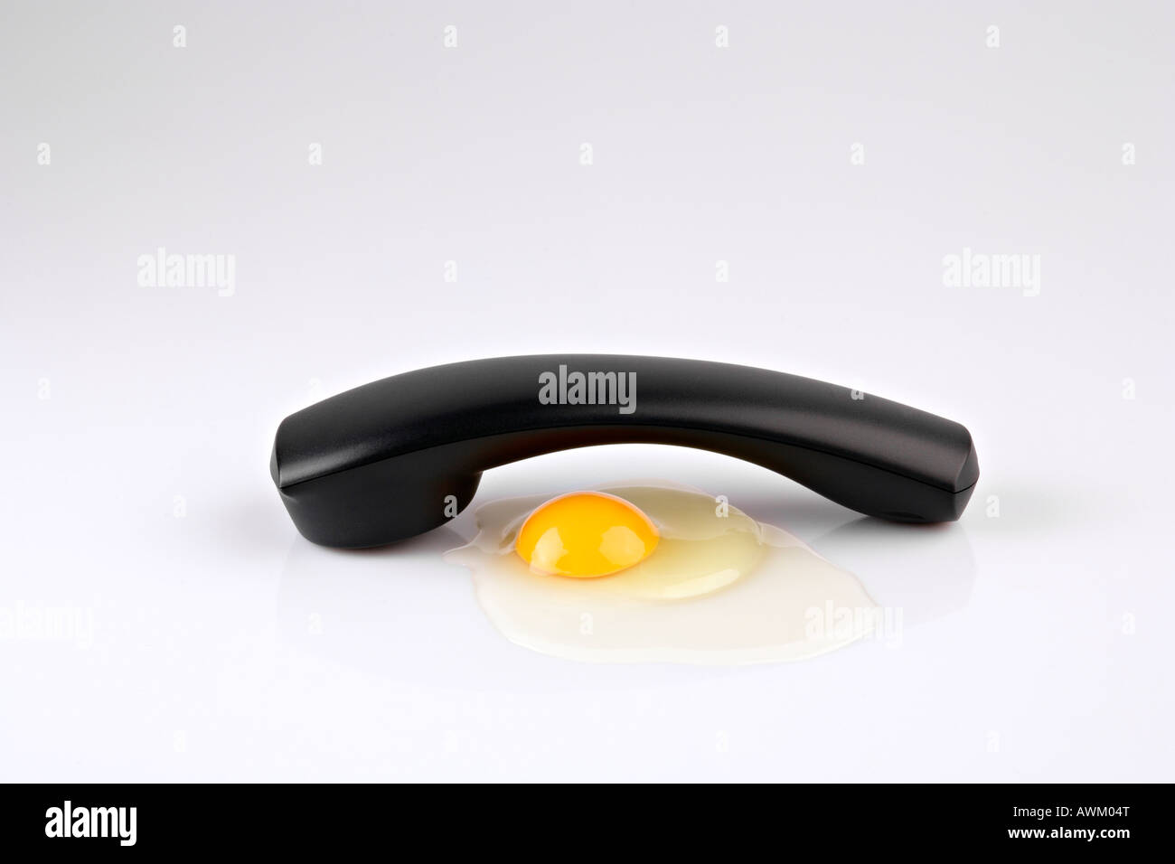 Telephone receiver beside egg yolk Stock Photo