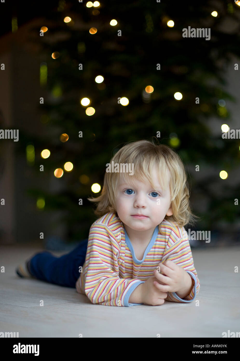 Boy lying in front of a christmas tree Stock Photo