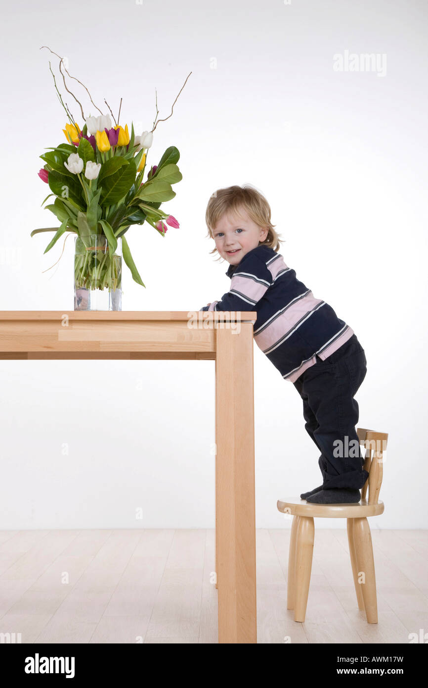 Boy standing on a chair Stock Photo