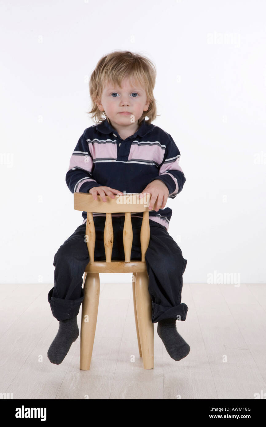 Boy sitting on a chair Stock Photo