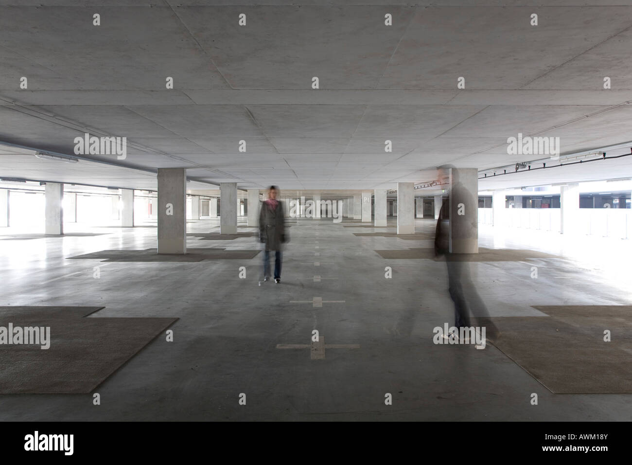 Two people in a deserted parking garage Stock Photo