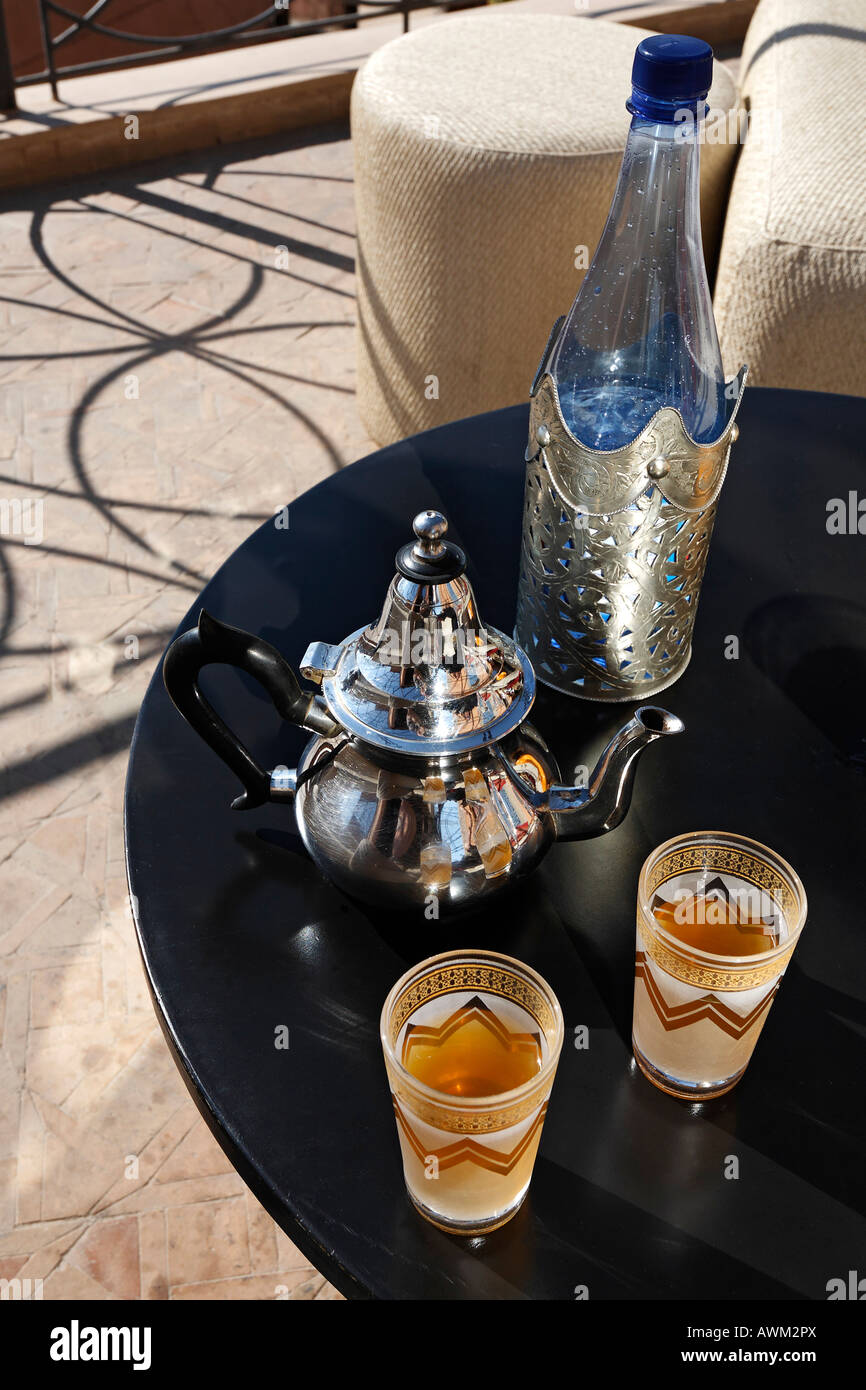 Ornate Moroccan teapot and glasses on a black lacquer table in the
