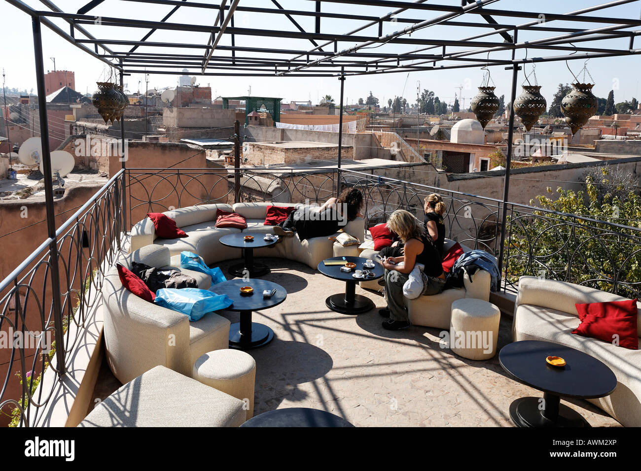 Young female tourists relaxing on the rooftop patio of Café Arabe, enjoying the view over the historic Medina quarter, Marrakes Stock Photo