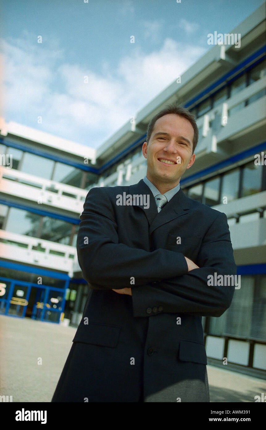 Portrait of businessman smiling in front of office building Stock Photo ...