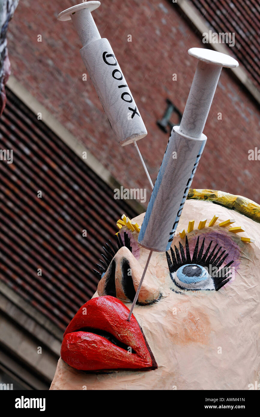 Paper-maché woman with collagen and botox needles sticking in her lips and  face, Carnival (Mardi Gras) parade in Duesseldorf, N Stock Photo - Alamy
