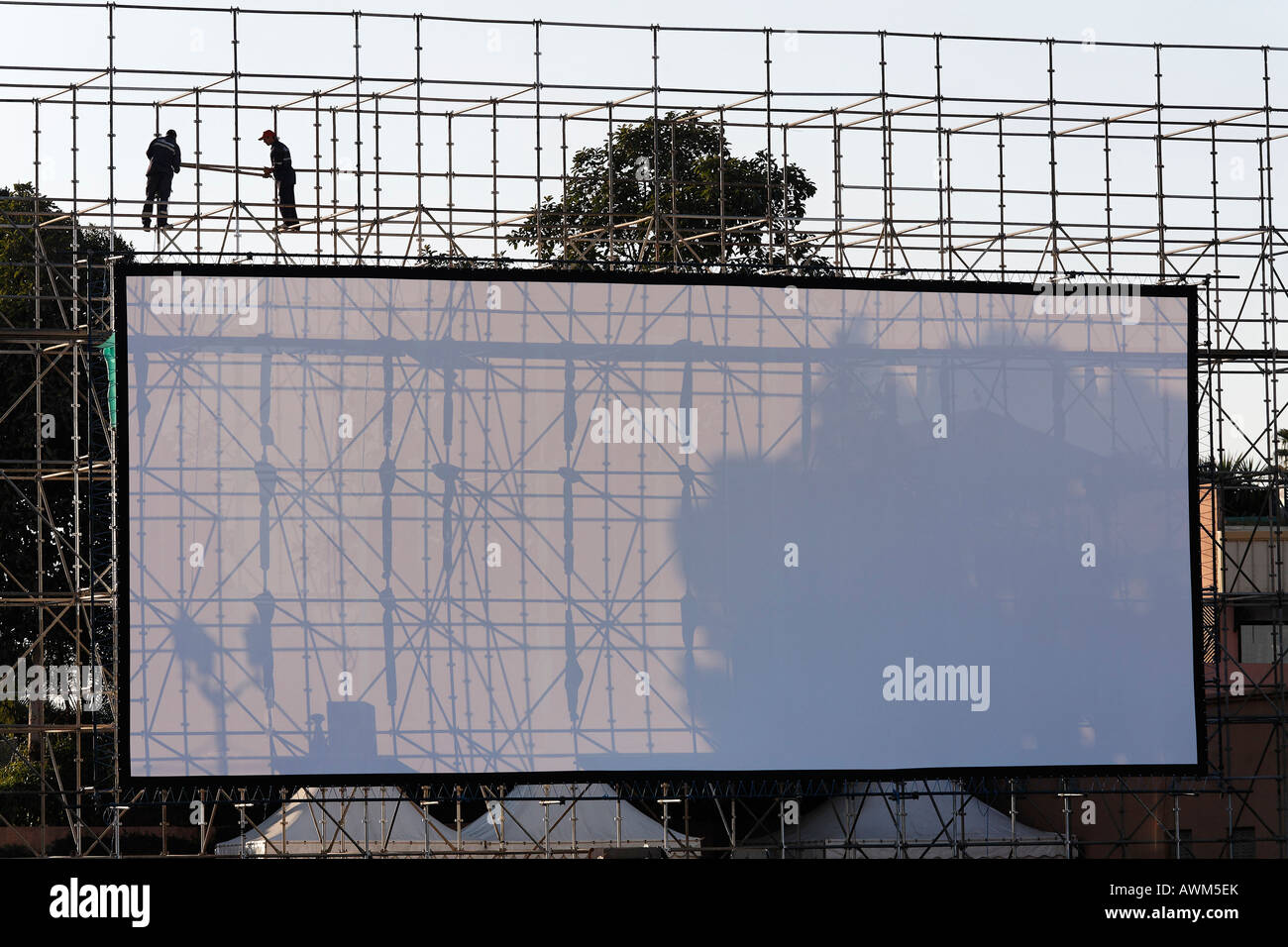Two men installing a huge open-air screen, Djemaa el-Fna, Marrakech, Morocco, Africa Stock Photo