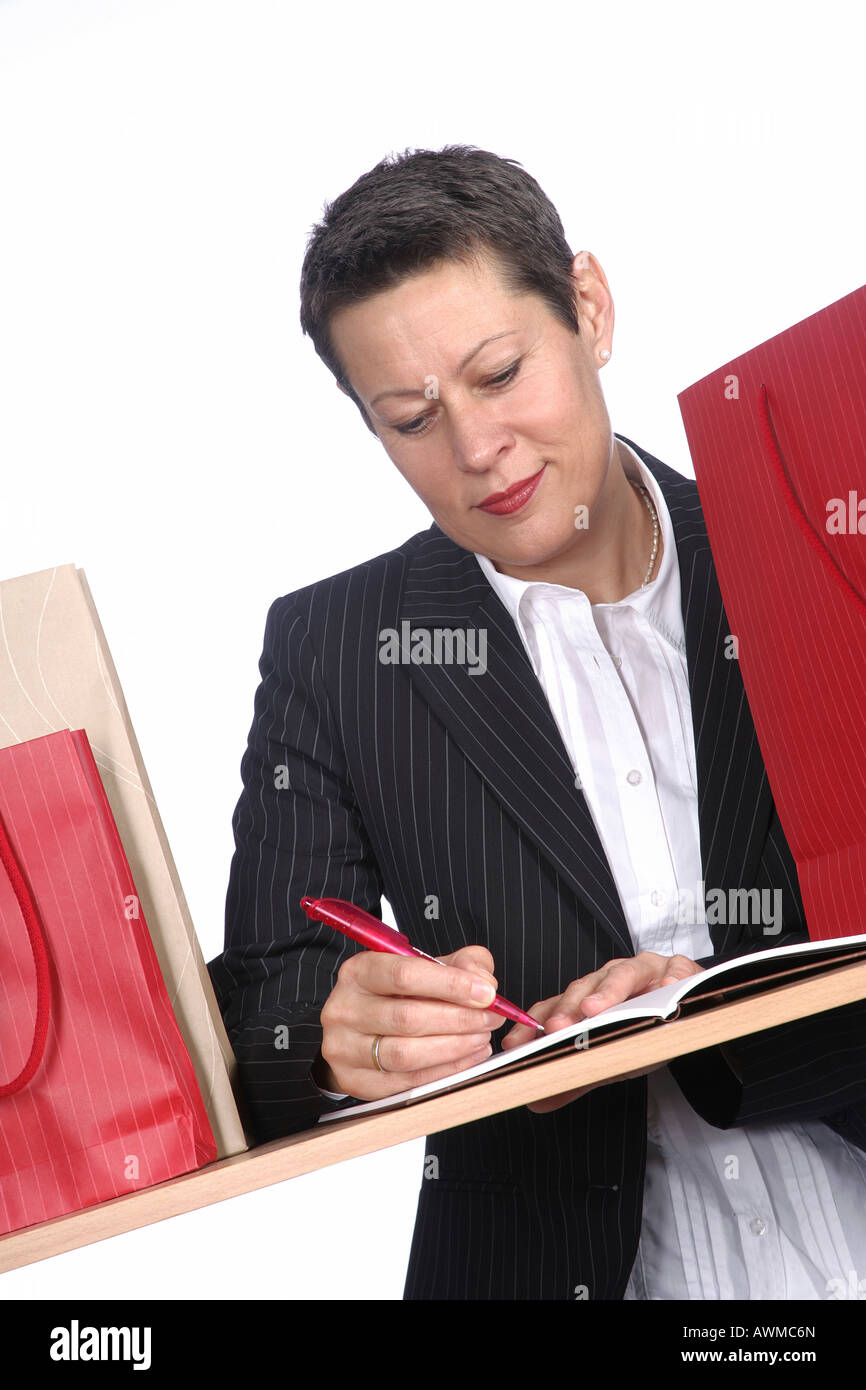 Woman composing shopping list Stock Photo