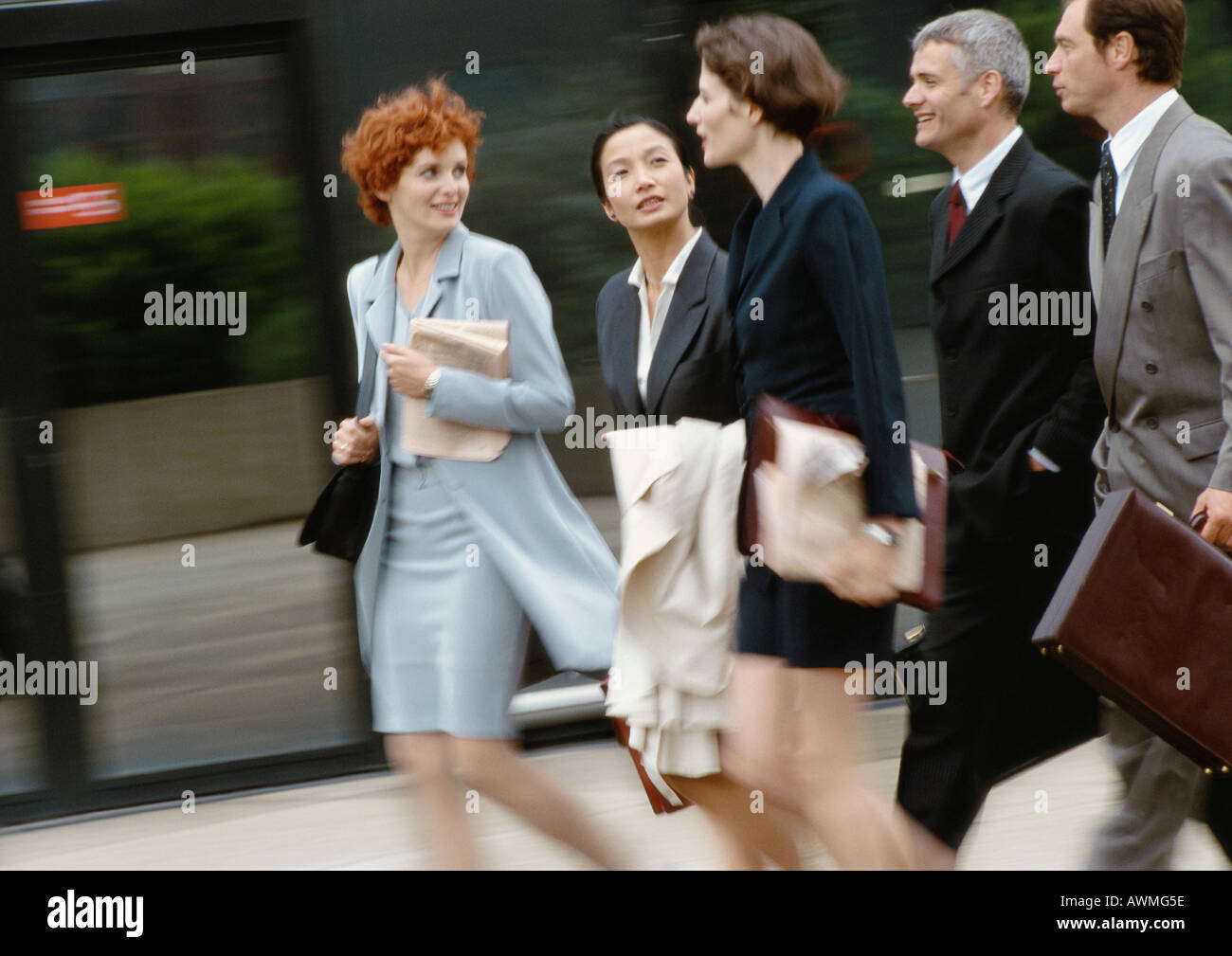 Group of business people walking side by side, blurred Stock Photo - Alamy