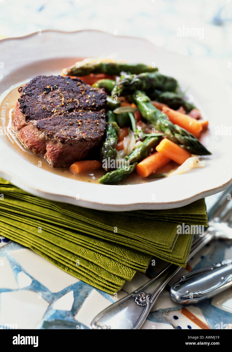 Steak with asparagus and carrots on plate, close-up Stock Photo