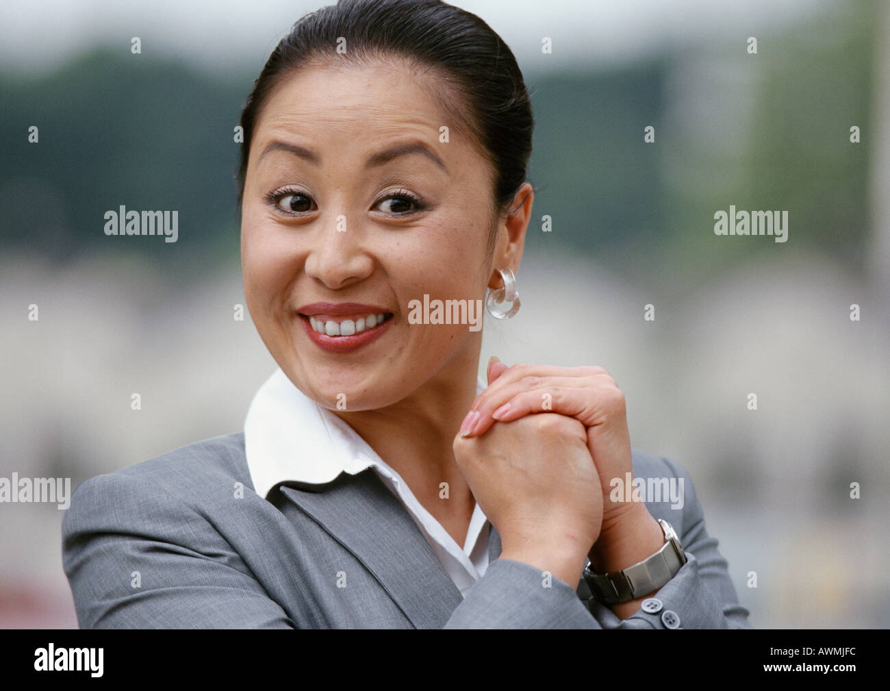 Businesswoman smiling, hands together, portrait Stock Photo