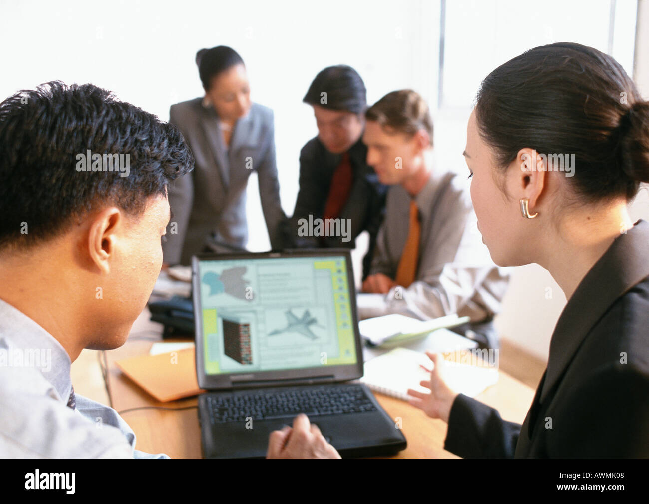 Business associates discussing image displayed on computer screen Stock Photo