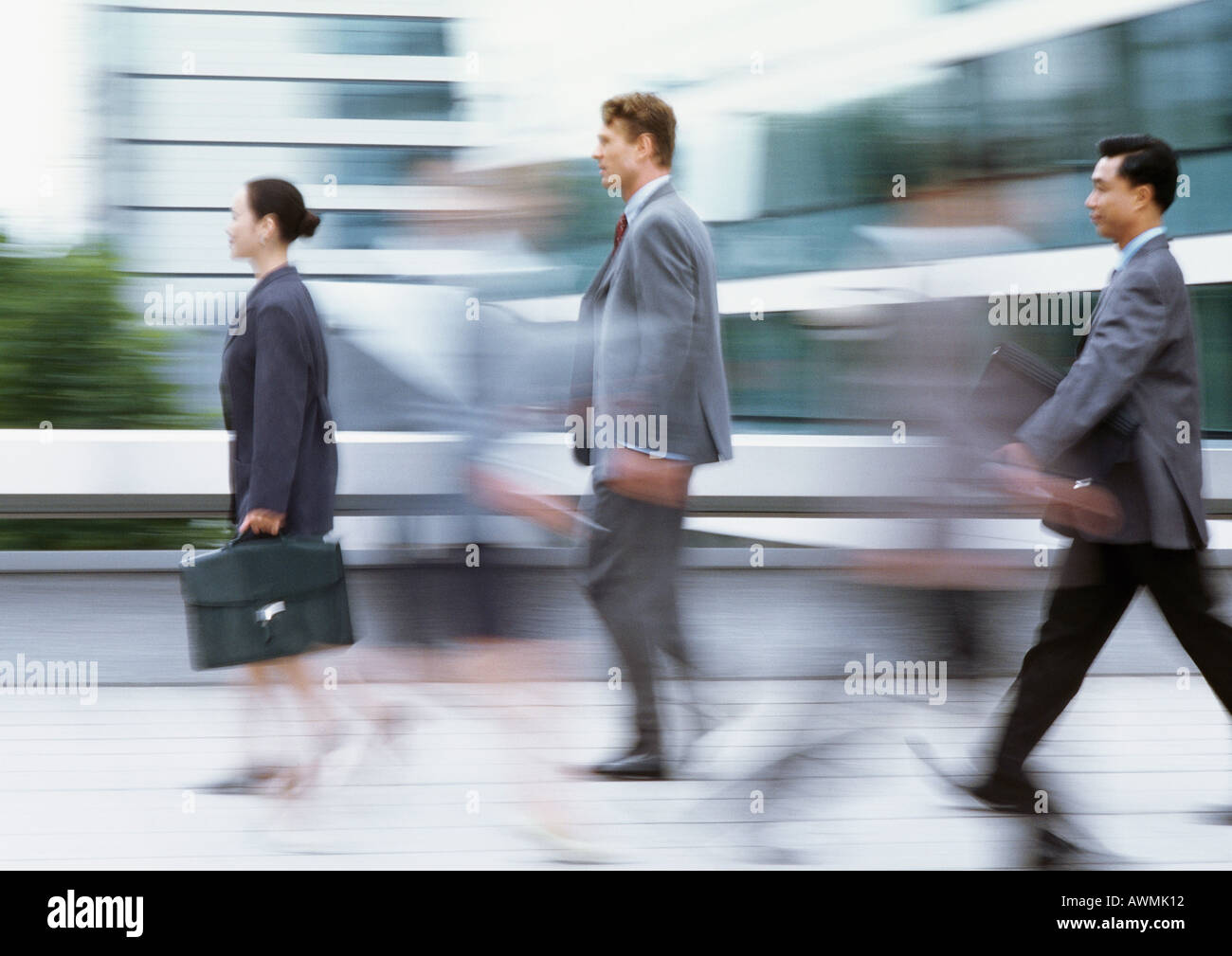 Three business people walking with briefcases, side view, blurred Stock ...