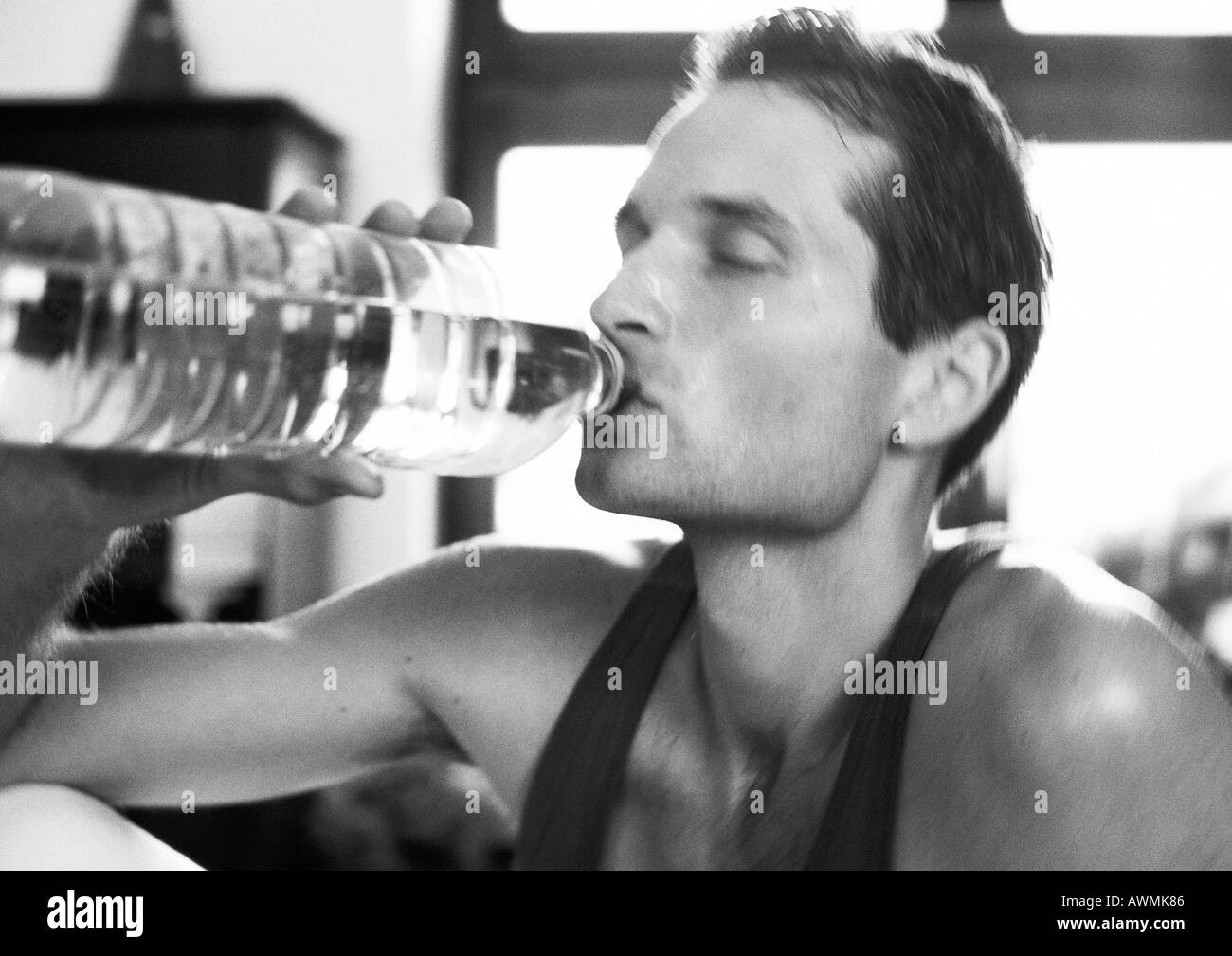 Man drinking from bottle, close-up, b&w Stock Photo
